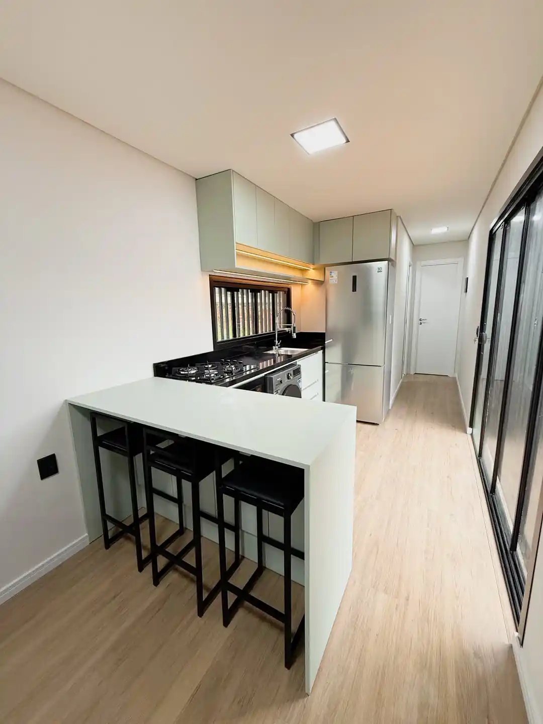 1. Sage Green Kitchen with a Breakfast Bar