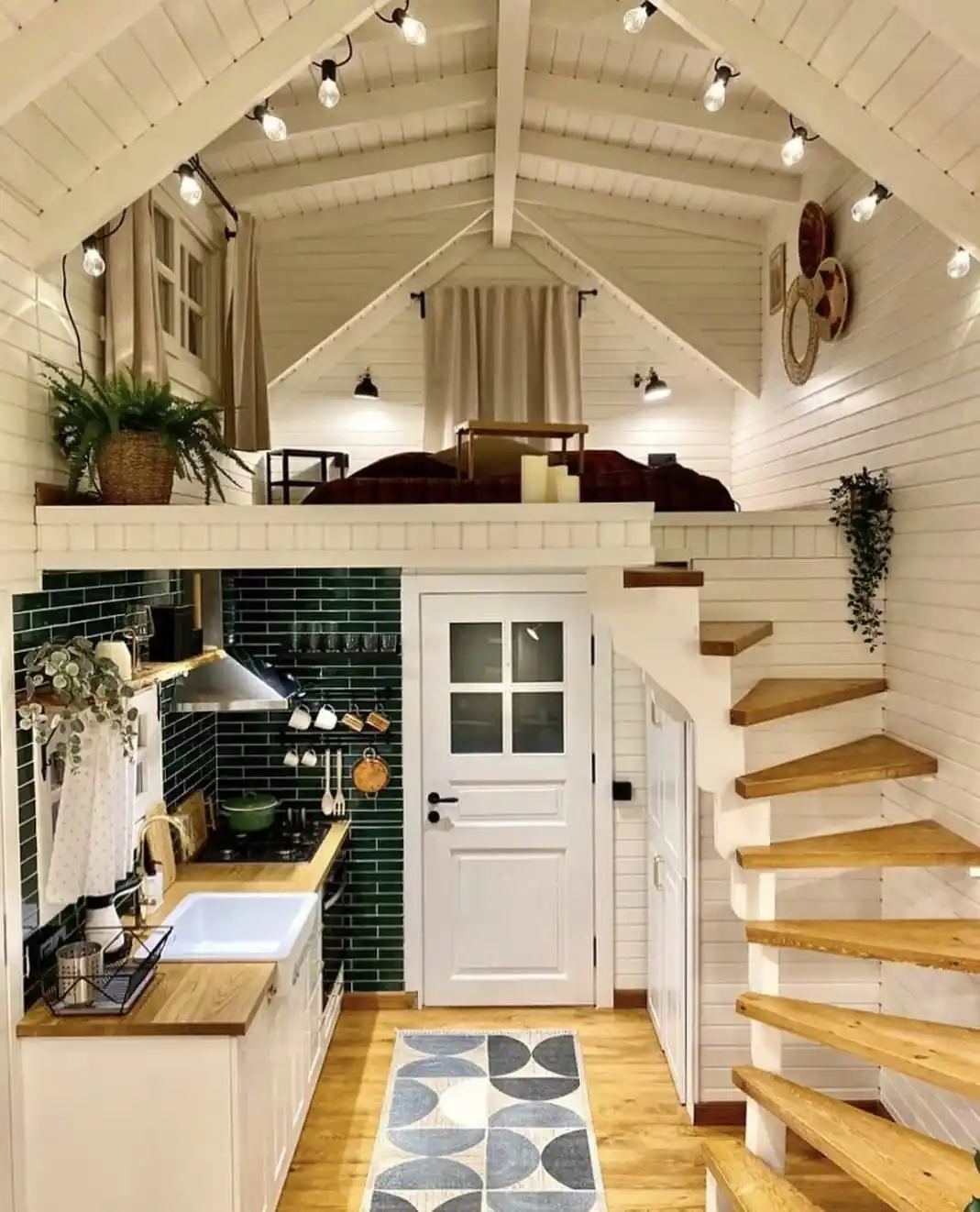 17. White Plank Tiny House Interior with Green Tile Kitchen and Winding Stairs