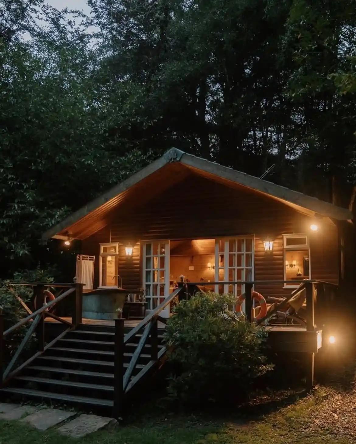 15 Tiny House Ideas for Couples Who Live Small Full-Time 15 14. Dark Timber Cabin With an Outdoor Soaking Tub