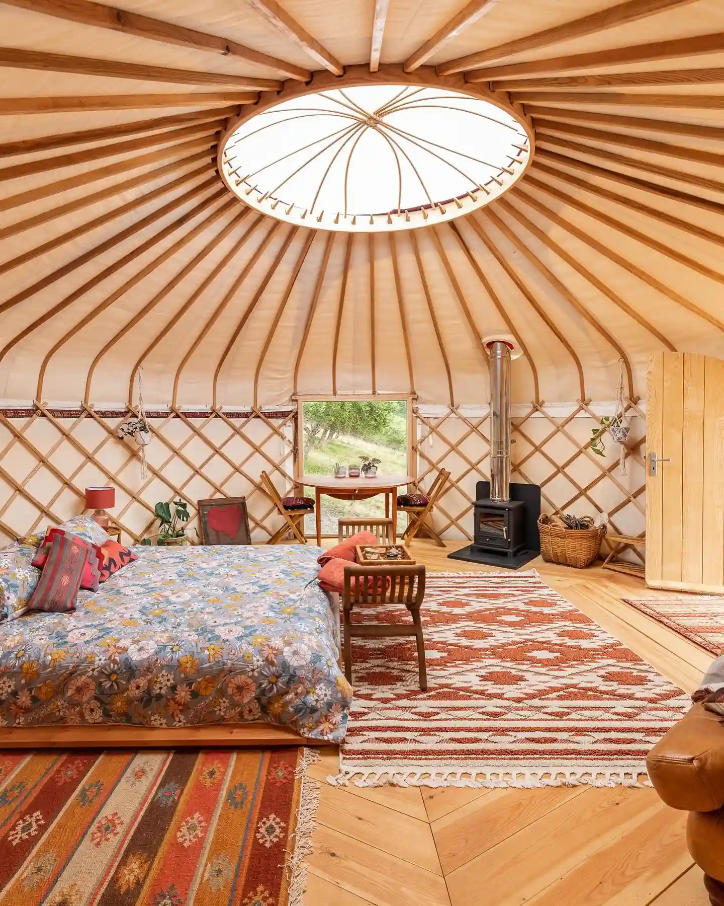 17 Yurt Living Ideas for a Cozy Off-Grid Lifestyle 10 9. Layered Rugs on a Chevron Pine Floor