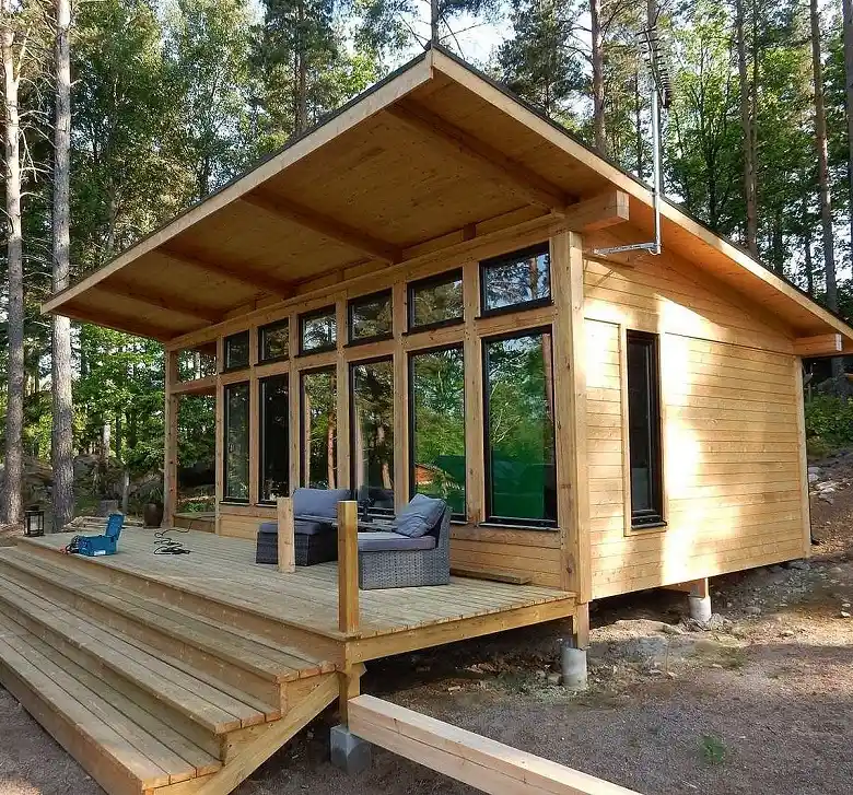 16. Blond Timber Cabin With a Sloped Roof and Full Glass Wall