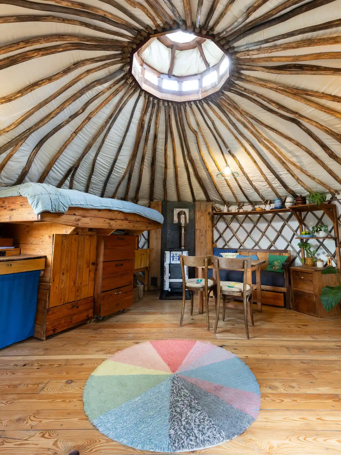 17 Yurt Living Ideas for a Cozy Off-Grid Lifestyle 3 2. A Round Pastel Rug Under a Rustic Roof