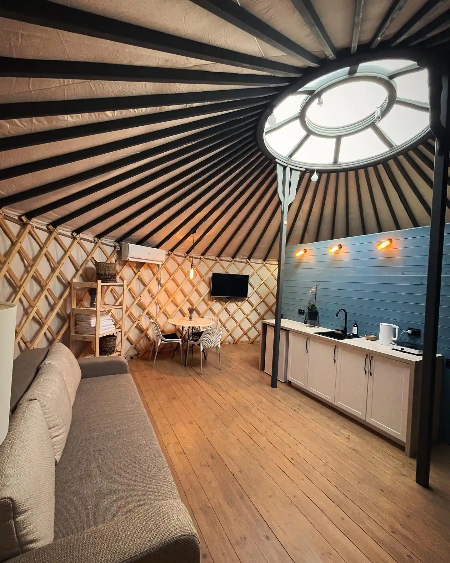 17 Yurt Living Ideas for a Cozy Off-Grid Lifestyle 16 15. A Blue Shiplap Kitchen Wall With Amber Sconces